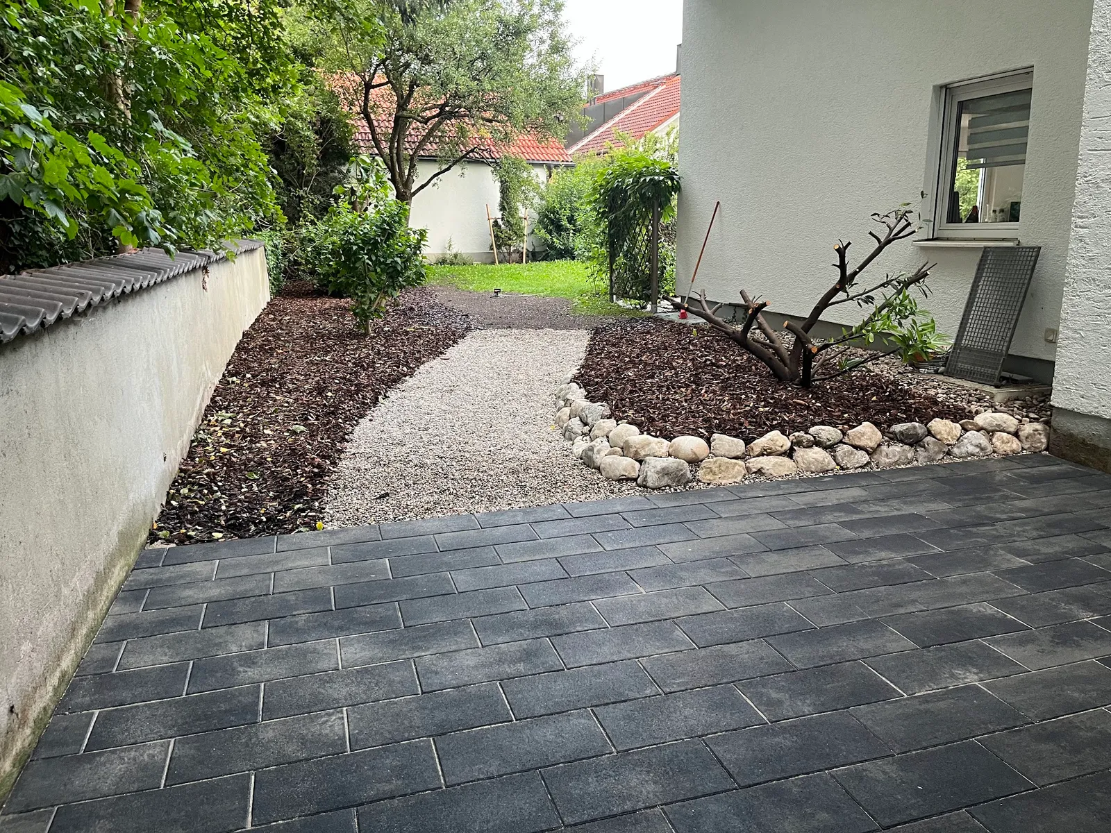 Gepflasterte Terrasse mit Naturstein und Kiesweg